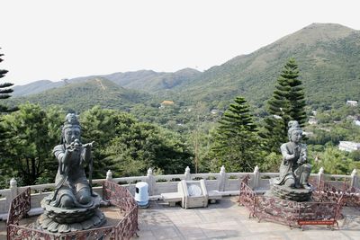 Statue by trees against clear sky