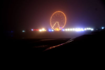 Illuminated ferris wheel at night