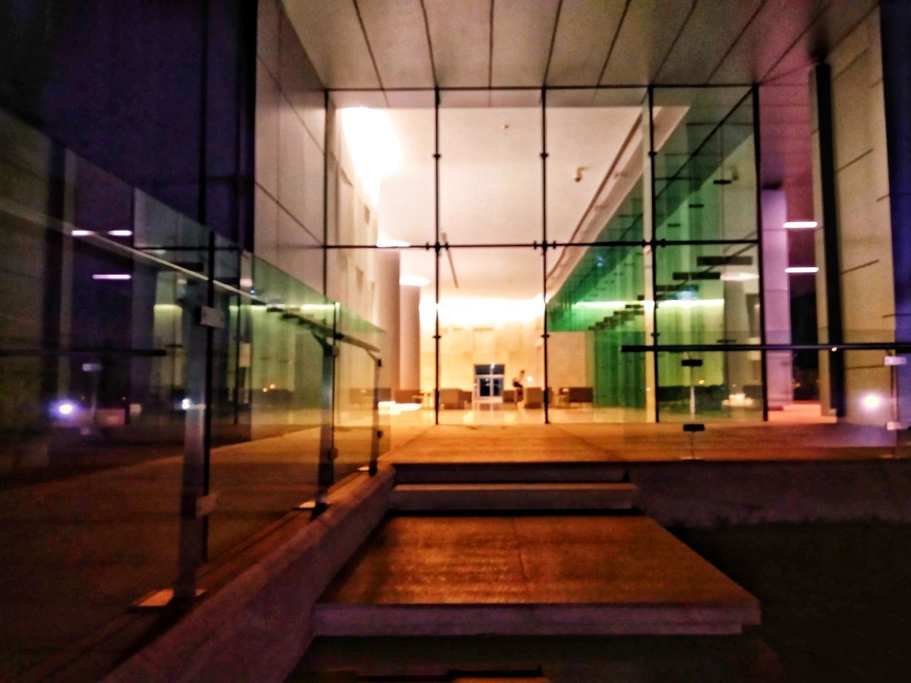 MAN WALKING ON ILLUMINATED CORRIDOR