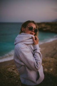 Side view of man wearing sunglasses standing on beach