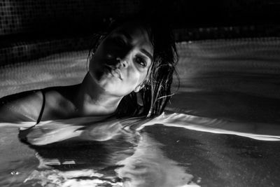 Portrait of woman swimming in pool at night