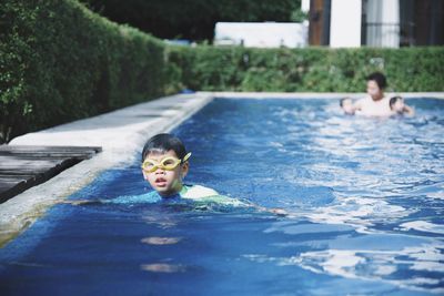 Portrait of young woman swimming in pool