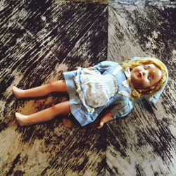 High angle view of old doll on hardwood floor