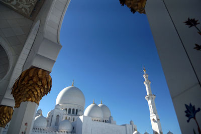 Low angle view of grand mosque against clear blue sky