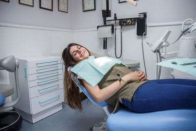 Portrait of smiling young woman sitting on dentist chair