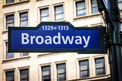 Low angle view of road sign against blue sky