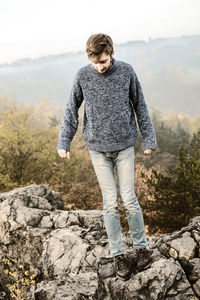 Teenager standing on rock formation