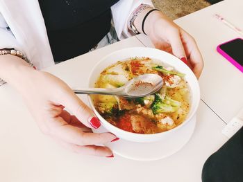 High angle view of woman holding food on table