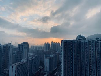 Modern buildings in city against sky during sunset