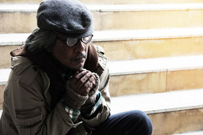 Beggar sitting on steps in city