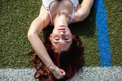 Portrait of young woman lying on field