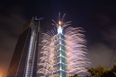 Low angle view of firework display at night