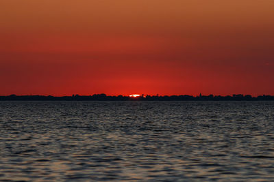 Scenic view of sea against romantic sky at sunset