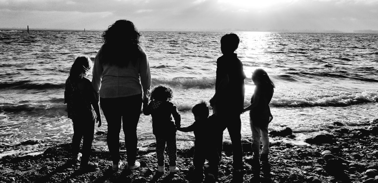 sea, water, child, women, beach, land, real people, family, togetherness, group of people, childhood, girls, sky, parent, leisure activity, mother, adult, males, daughter, horizon over water, positive emotion, outdoors, sister, son