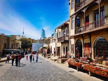 People walking on street amidst buildings in city