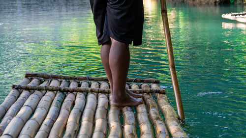 Low section of man standing in lake