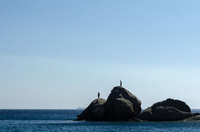 View of rock in sea against clear sky