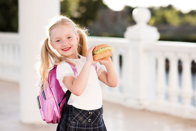 Portrait of cute girl holding hamburger