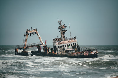 Fisherman boat in sea against clear sky