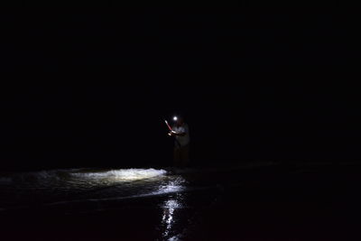 Scenic view of illuminated sea against clear sky at night