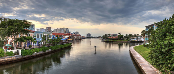 River amidst buildings in city against sky