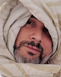 Close-up portrait of man relaxing on bed