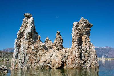 Panoramic view of rock formation against clear blue sky