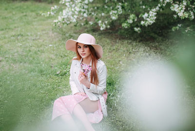 Young woman wearing hat standing on field