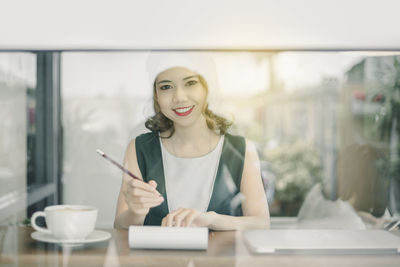 Portrait of smiling young woman working office
