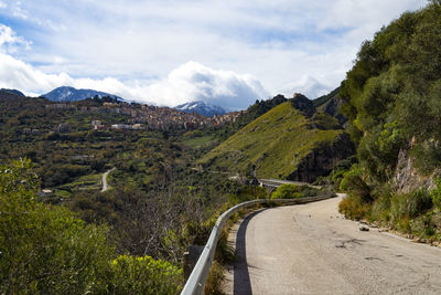 Country road and the village of isnello on the italian island of sicily