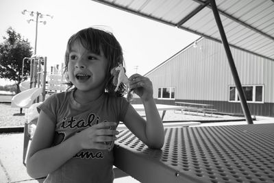 Close-up of girl playing with toy while standing by table outdoors