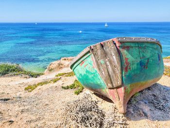 Deck chairs on beach against blue sky