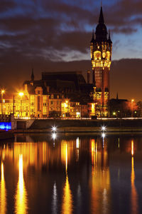 Illuminated buildings in water at night