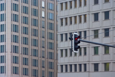 Low angle view of stoplight against buildings in city