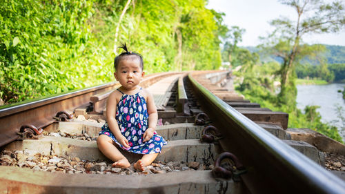 Portrait of baby sitting on railroad track