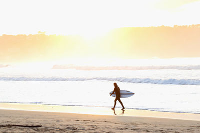 Rear view of woman walking on beach