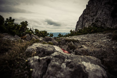 Surface level of rocks on mountain against sky