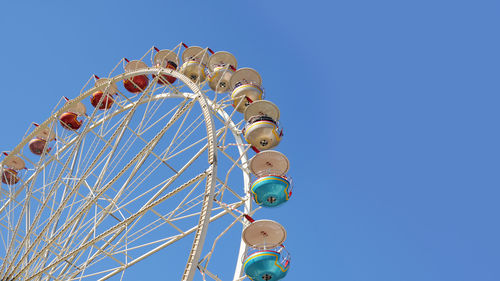 Ferris wheel on clear blue sky with copy space