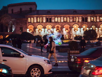 People standing on illuminated street at night