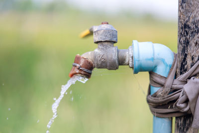 Close-up of faucet against blue water