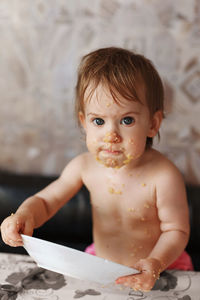 A funny child holds a plate and eats porridge. emotional facial expression
