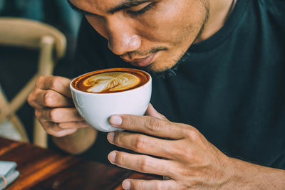 Midsection of man holding coffee cup