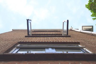 Low angle view of open window against sky