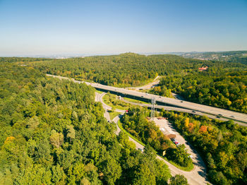 High angle view of road amidst trees against clear sky