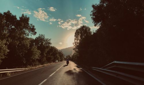 Road amidst trees against sky