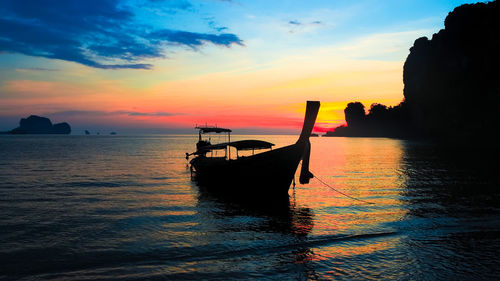 Silhouette boat in sea against sky during sunset