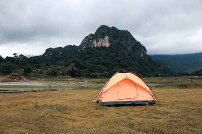 Tent on field by mountain against sky