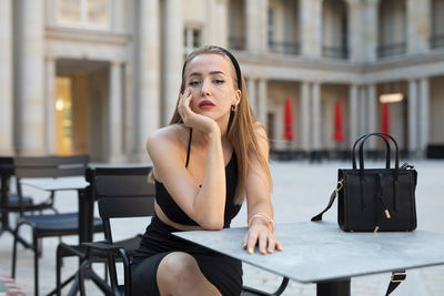 Young woman using mobile phone while sitting in cafe