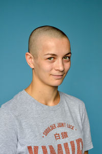 Close-up portrait of young man against blue background