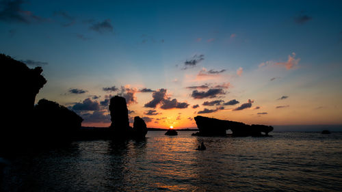 Silhouette boats in sea against sky during sunset